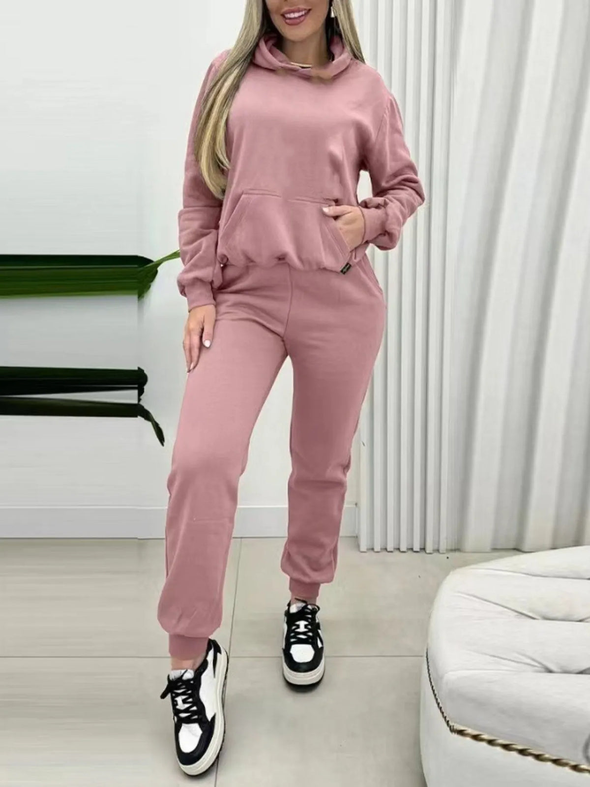 CLOTHRA matching long sleeve pullover hoodie and tapered joggers two piece lounge set in a clean minimalist street look. Front View