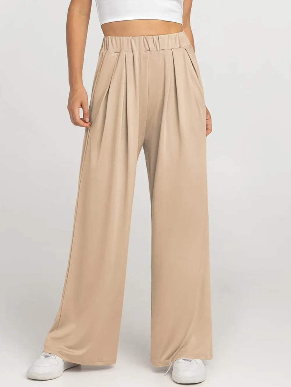 CLOTHRA minimalist elastic waist wide leg pants showing a relaxed baggy fluid drape in an authentic urban street look. in a color Tan
