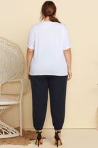 CLOTHRA women's plus size matching two piece streetwear tracksuit featuring a graphic tee and belted paperbag joggers with frill waist. in a Back side