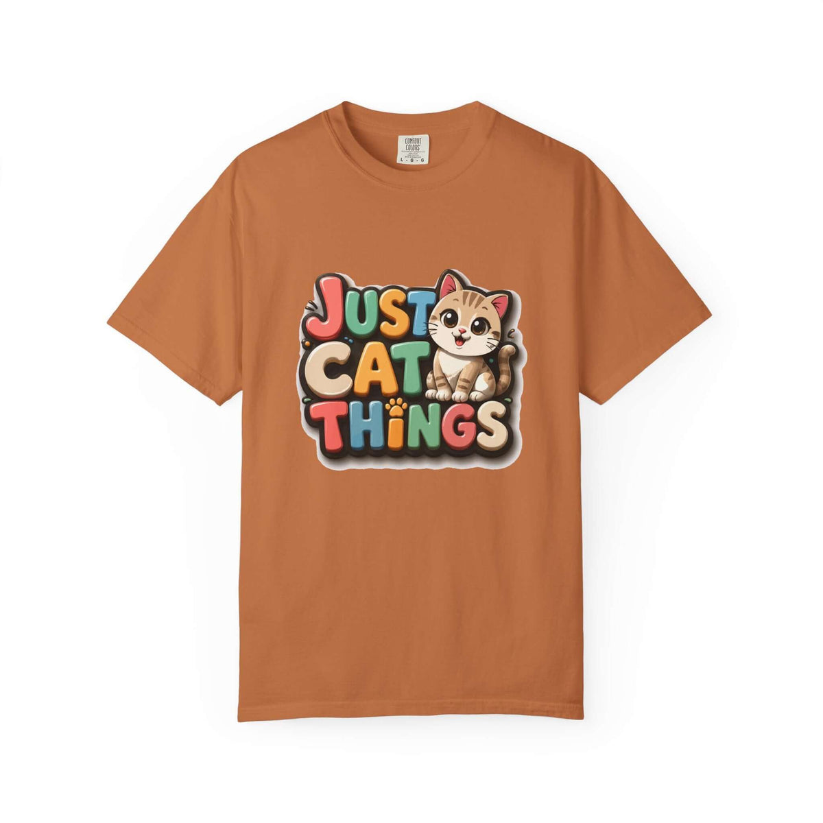 A rust-orange short-sleeve t-shirt with a colorful graphic on the chest that reads 'JUST CAT THINGS' next to a cartoon kitten. The shirt is displayed flat against a solid white background.