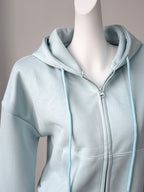 Close up of the durable front metal zipper, adjustable drawstrings, and split kangaroo pocket on CLOTHRA street style zip hoodie.