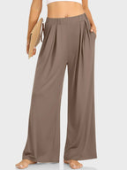 CLOTHRA minimalist elastic waist wide leg pants showing a relaxed baggy fluid drape in an authentic urban street look. in color Taupe
