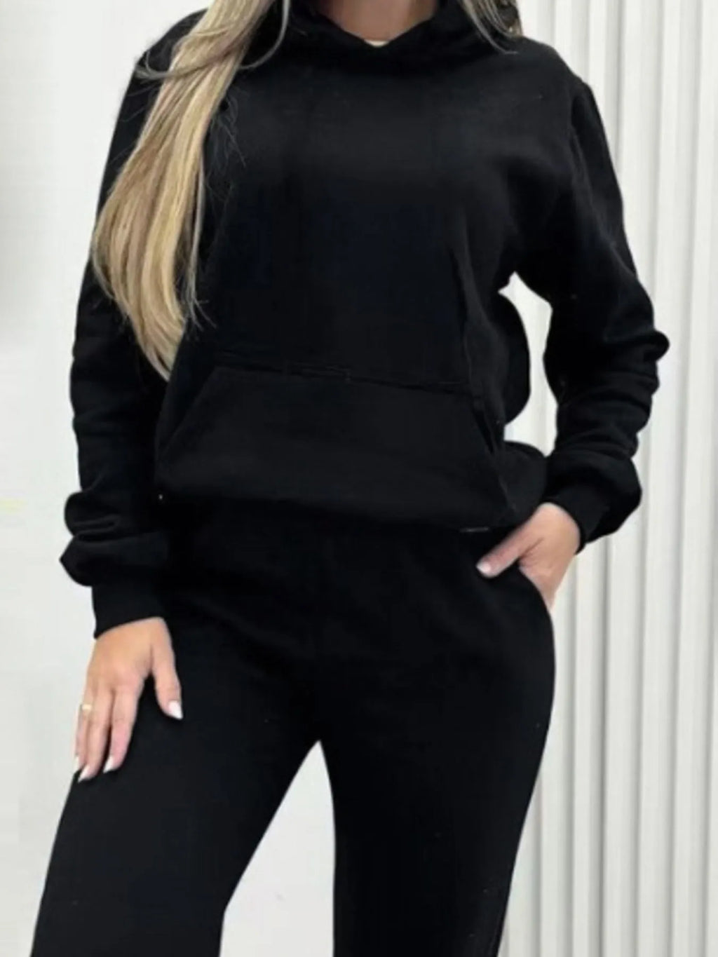 CLOTHRA matching long sleeve pullover hoodie and tapered joggers two piece lounge set in a clean minimalist street look. Close- up Black
