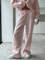 Close up shot of the secure side pocketing, flexible elastic waistband, and cuffed ankles on CLOTHRA matching lounge sweatpants. in a color Pink