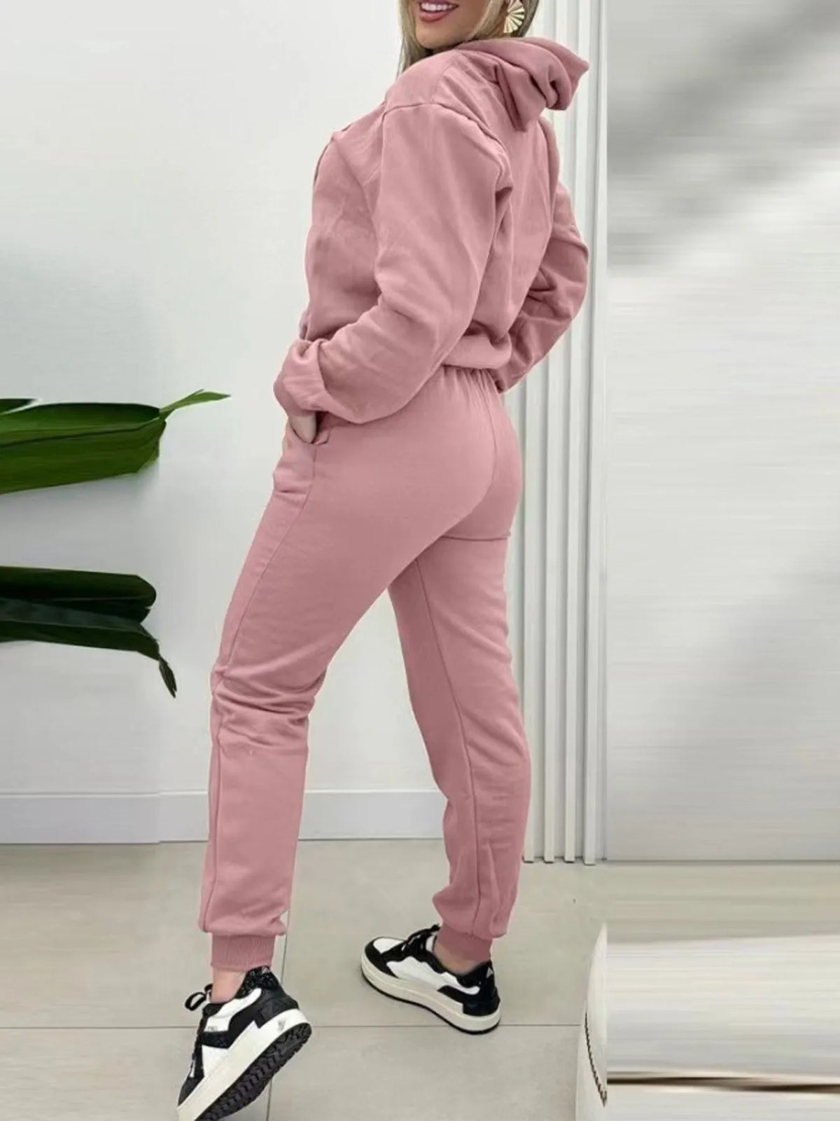 CLOTHRA matching long sleeve pullover hoodie and tapered joggers two piece lounge set in a clean minimalist street look. Side View