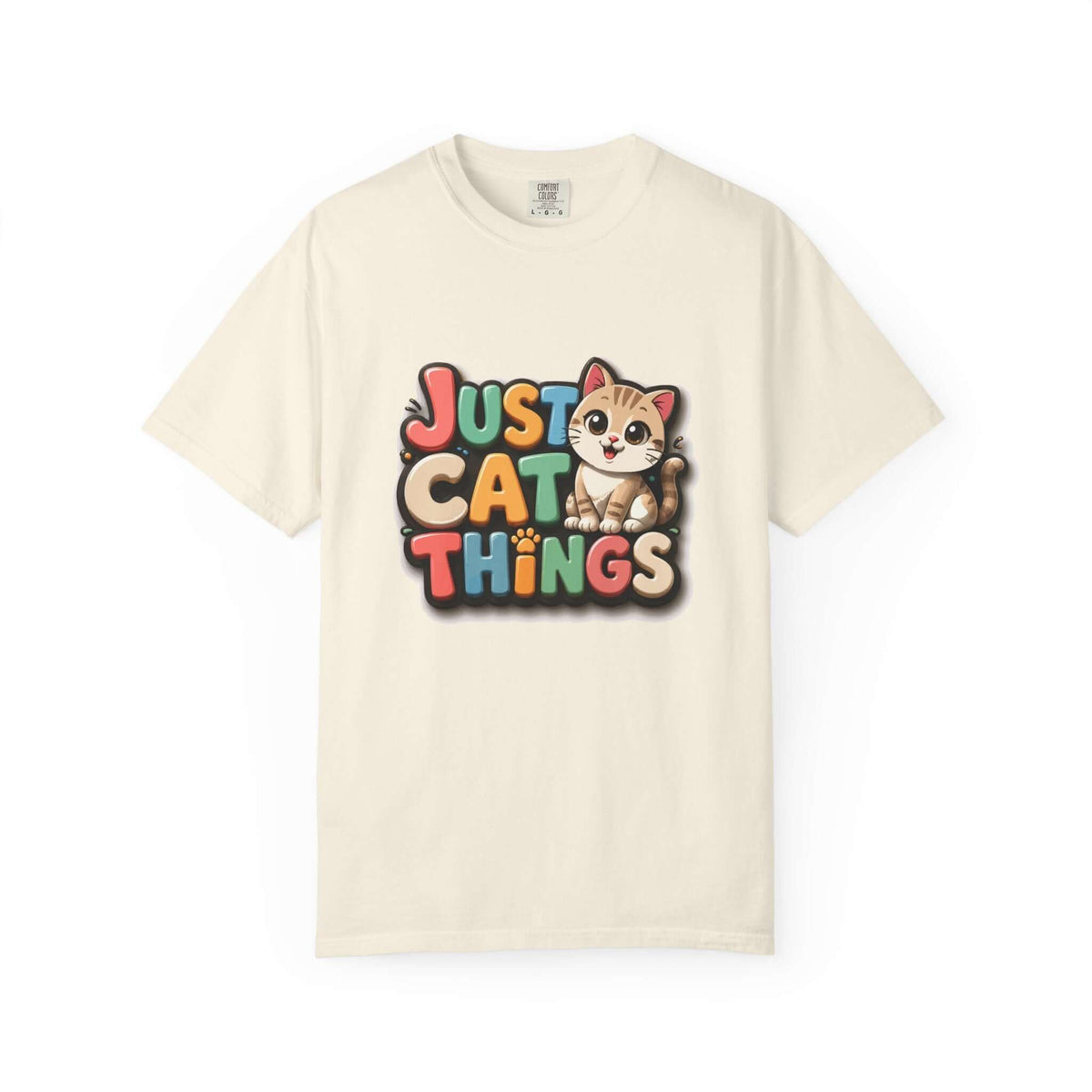 An off-white short-sleeve crewneck t-shirt featuring a colorful graphic on the chest that reads 'JUST CAT THINGS' in a retro, multi-colored bubble font, accompanied by a cute cartoon cat sitting on the letter 'O'.