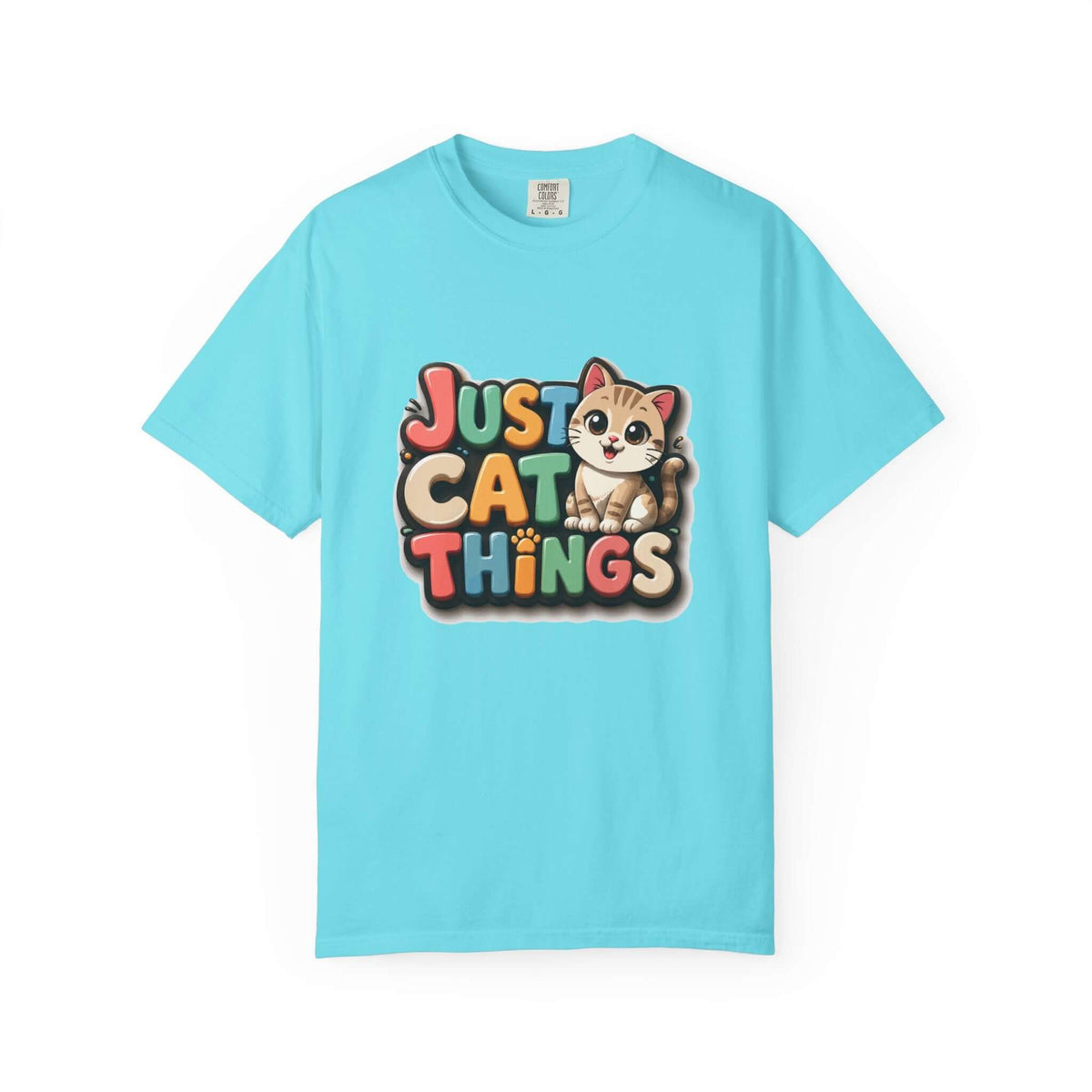 A light blue short-sleeve crewneck t-shirt featuring a colorful graphic on the chest that reads 'JUST CAT THINGS' in a playful multicolor font, accompanied by a cute cartoon kitten sitting on the lettering.