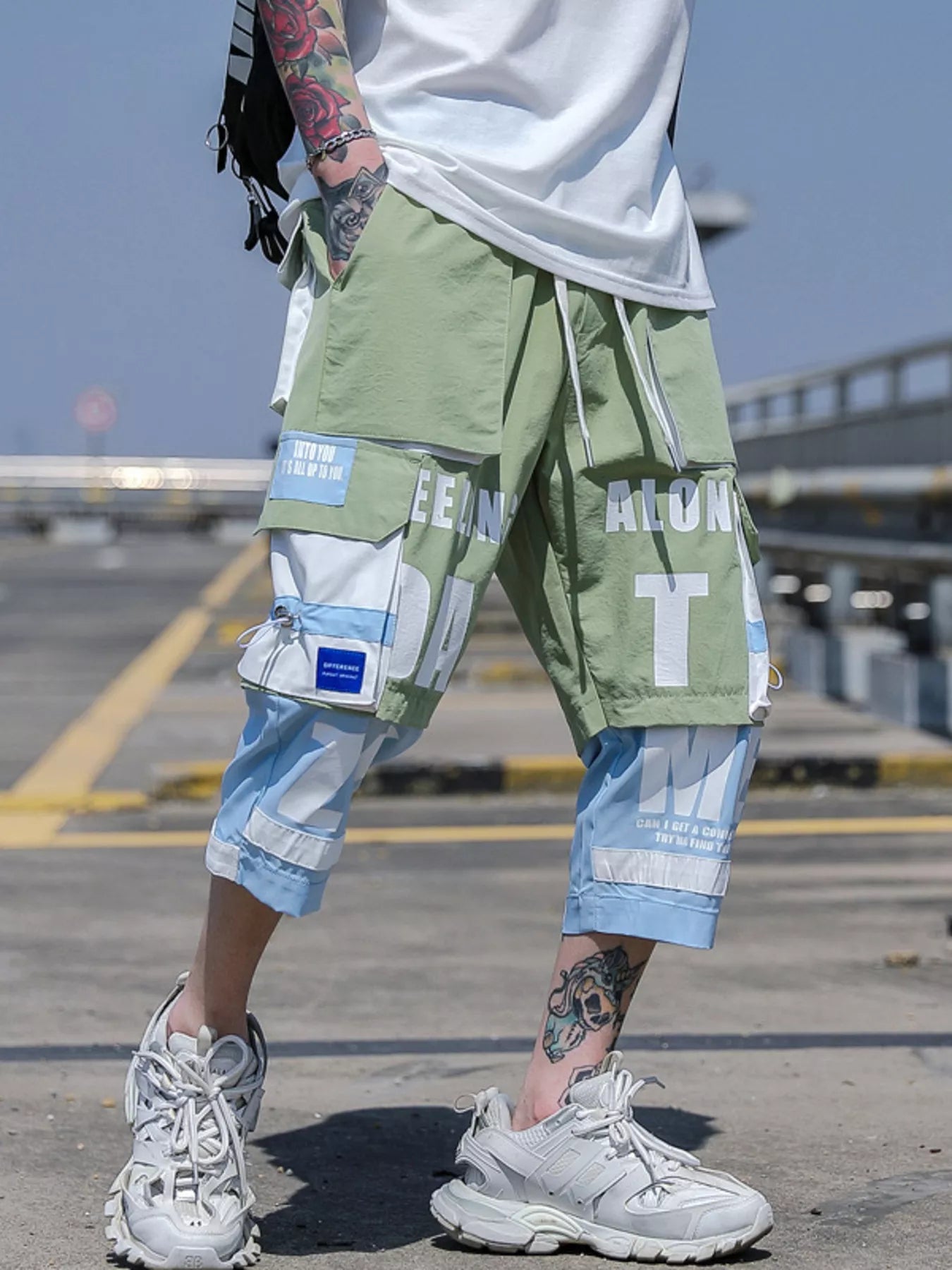 Detailed side view showing the geometric color block paneling and spacious side cargo pocket on CLOTHRA plus size men pants.