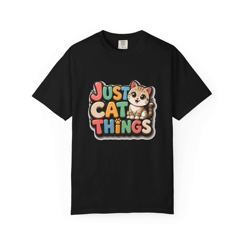 A black short-sleeve crewneck t-shirt featuring a colorful graphic on the chest that reads 'JUST CAT THINGS' in a retro, multi-colored bubble font next to a cute cartoon kitten.
