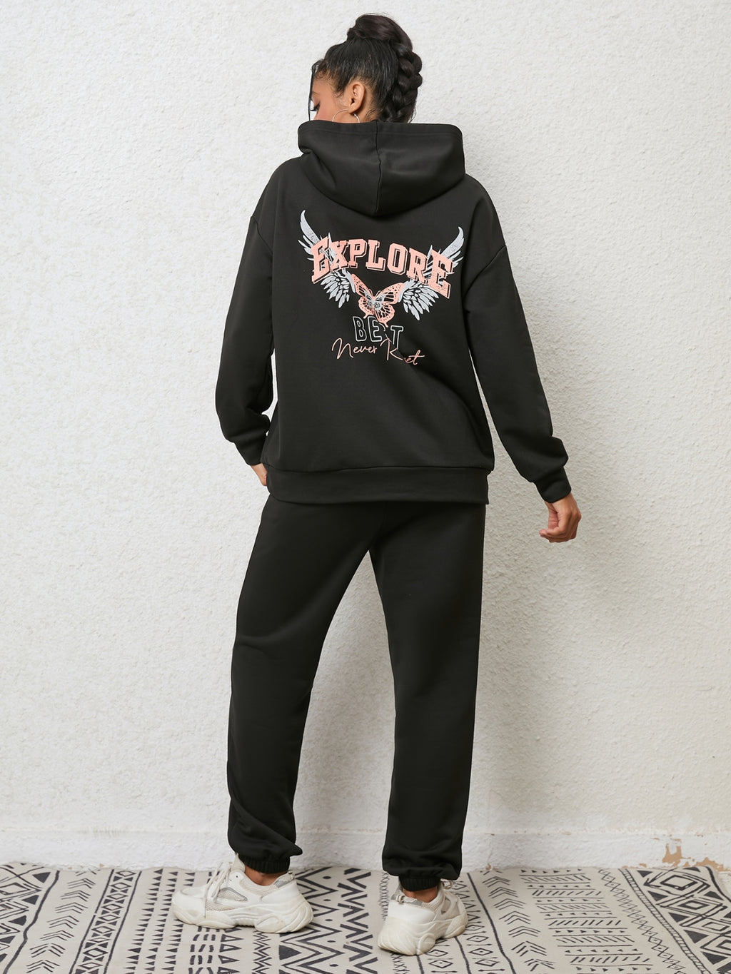 CLOTHRA matching drop shoulder graphic hoodie and cuffed sweatpants two piece streetwear tracksuit set in an oversized urban look. Back side view