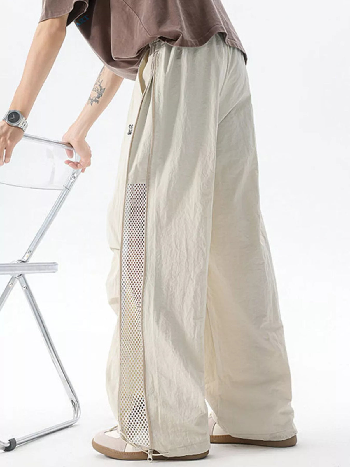 Close up of the wide non-roll elastic waistband and adjustable front drawstring on CLOTHRA men relaxed cargo pants. in a color Cream