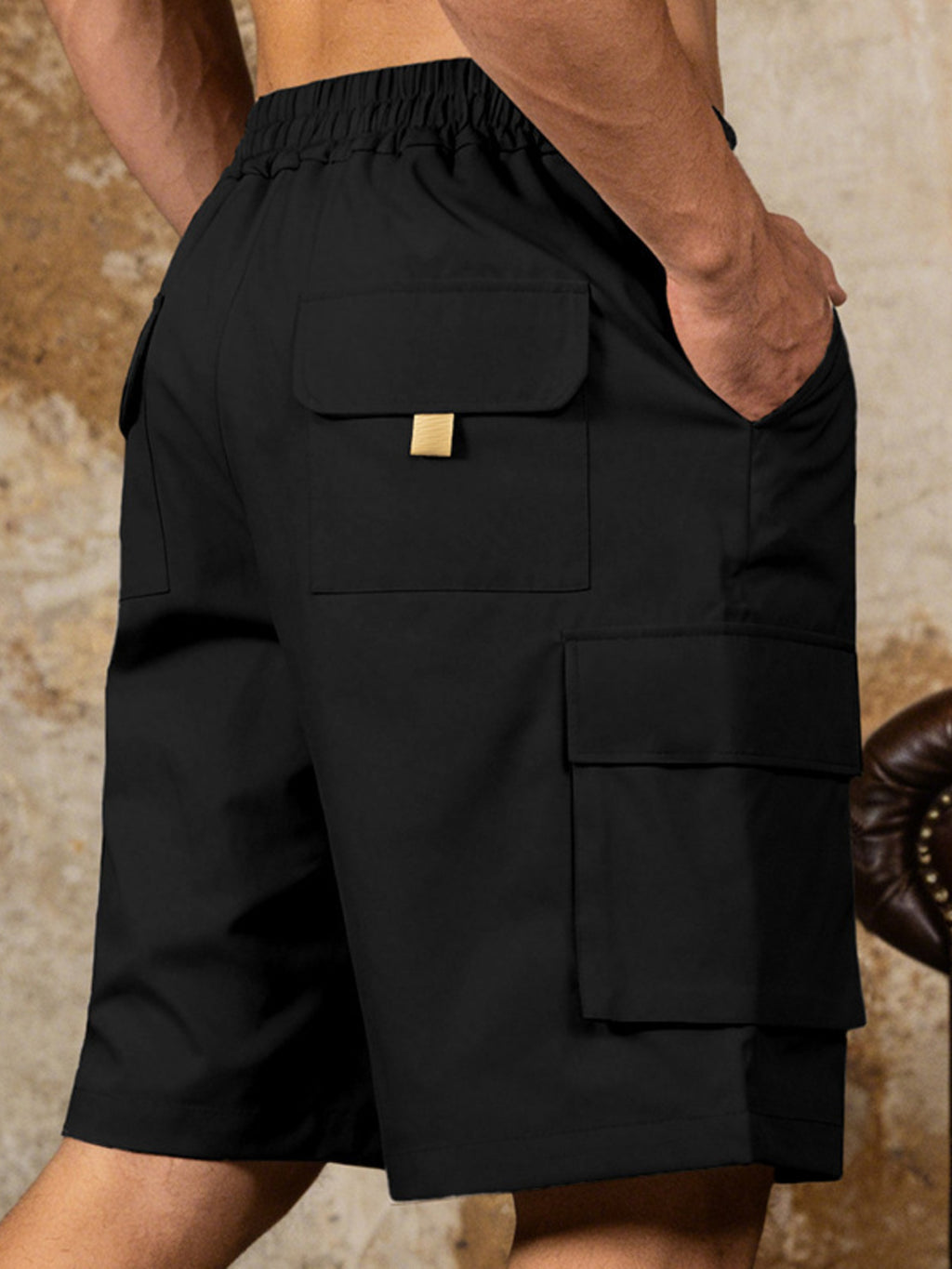 Detailed close up of the spacious side cargo pocket with durable double stitching on CLOTHRA men full size casual shorts. Black color side view