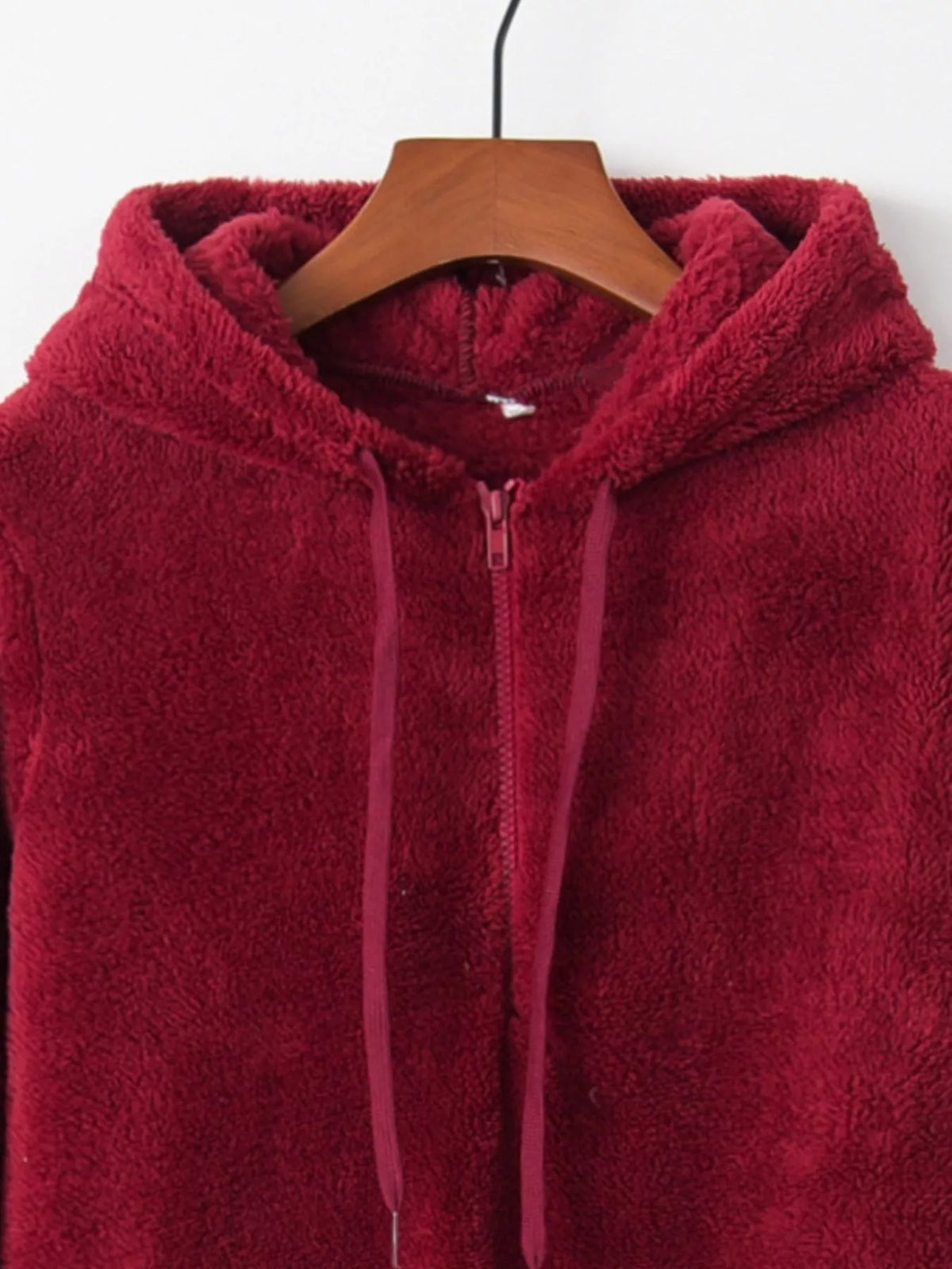 Detailed close up of the deep side hand pockets and ultra-soft woven fleece fabric texture on CLOTHRA unisex outerwear. in a color Burgundy