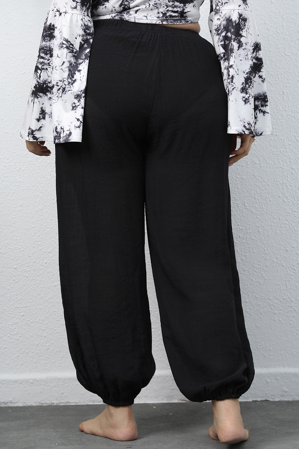 Close up shot of the adjustable tied drawstring waistband on CLOTHRA plus size jogger pants. Back side
