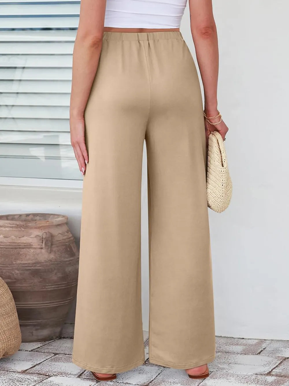 Close up of the secure flat lock stitching and flexible elastic waistband on CLOTHRA wide leg streetwear trousers. in Tan color Back side view