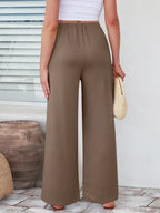 Close up of the secure flat lock stitching and flexible elastic waistband on CLOTHRA wide leg streetwear trousers. in color Taupe Back Side view