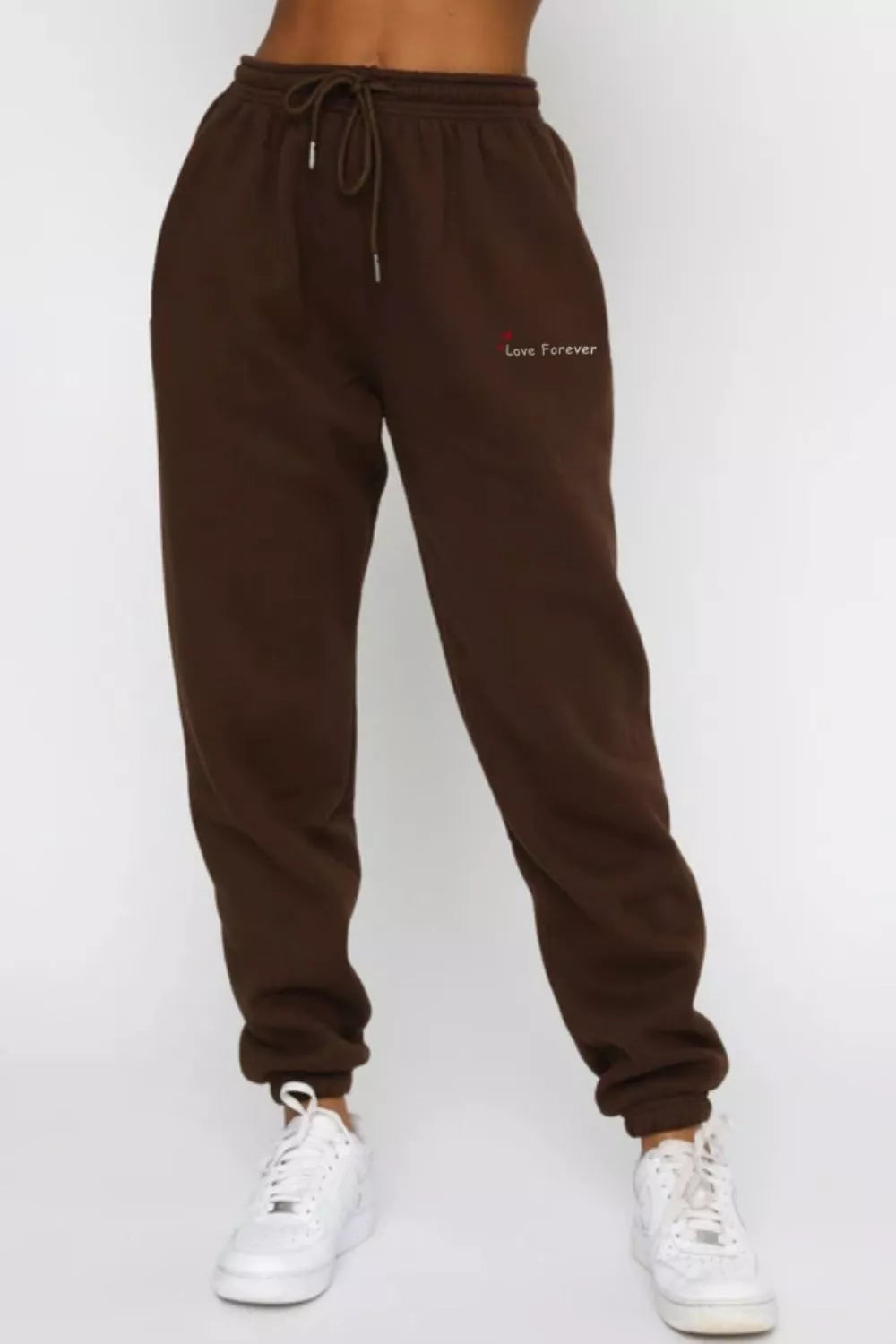 Close up shot of the adjustable drawstring waist and flexible ankle cuffs on CLOTHRA matching track pants.