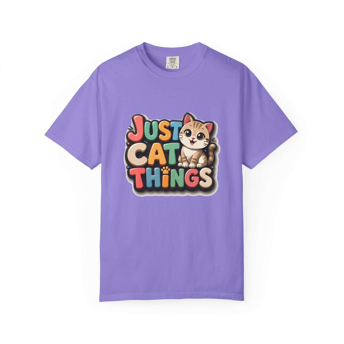 A purple short-sleeve crewneck t-shirt featuring a colorful graphic on the chest that reads 'JUST CAT THINGS' in a retro, multi-colored bubble font, accompanied by a cute cartoon cat sitting on the lettering.