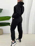 CLOTHRA matching long sleeve pullover hoodie and tapered joggers two piece lounge set in a clean minimalist street look. Side view Black