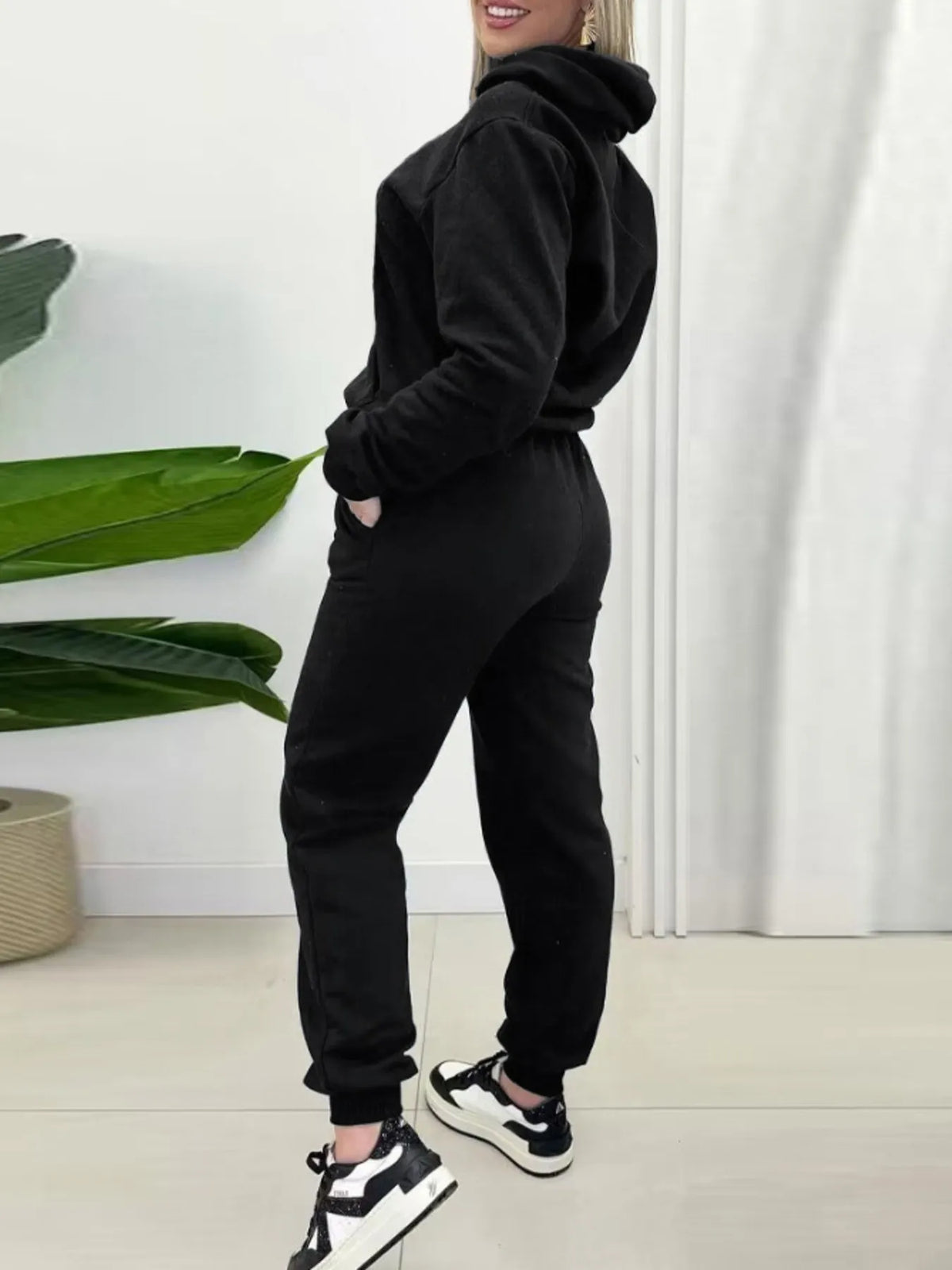 CLOTHRA matching long sleeve pullover hoodie and tapered joggers two piece lounge set in a clean minimalist street look. Side view Black