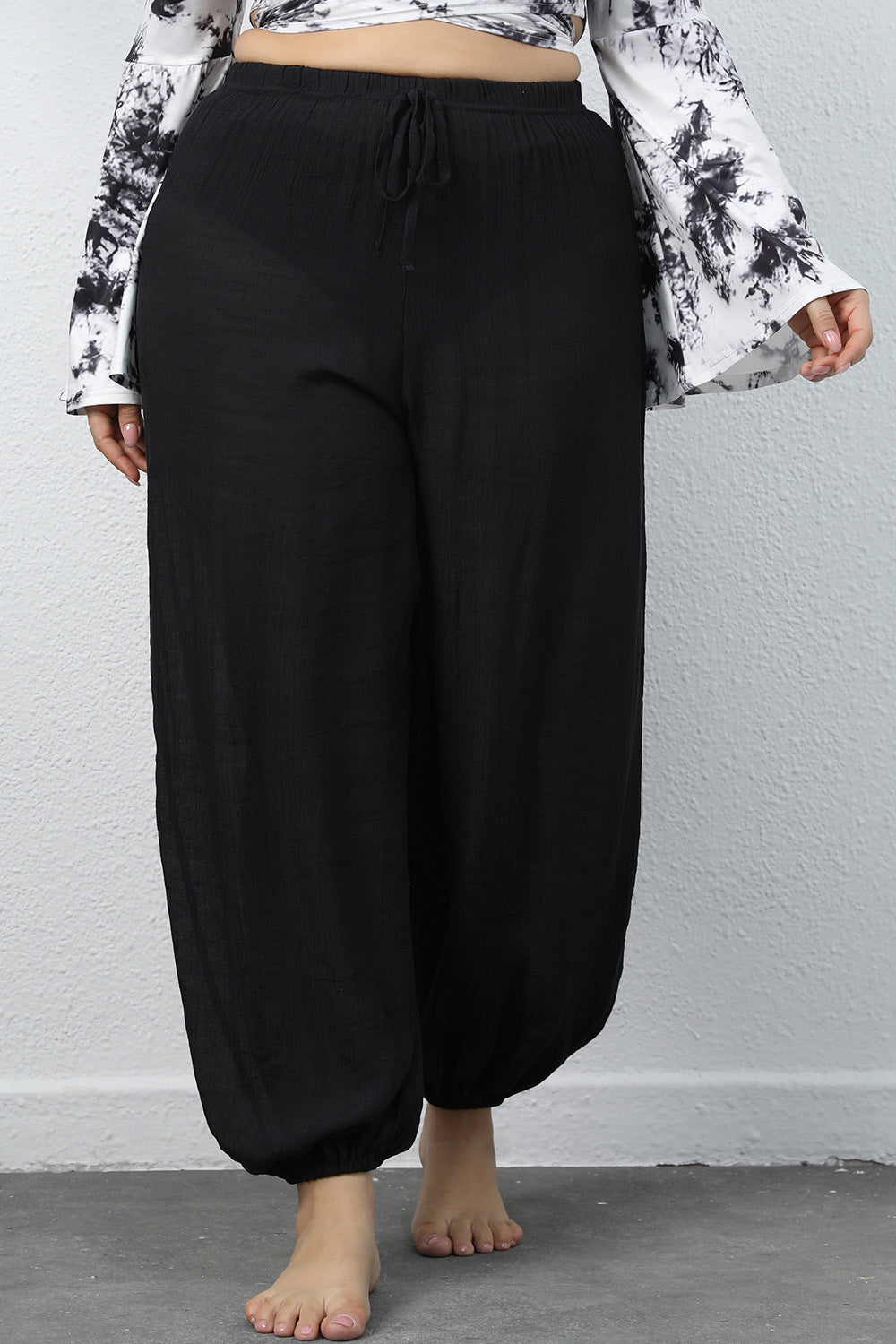 Plus size model wearing CLOTHRA comfy drawstring joggers for a stylish lounge and athleisure look.