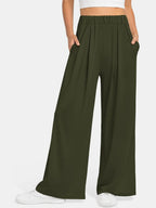 CLOTHRA minimalist elastic waist wide leg pants showing a relaxed baggy fluid drape in an authentic urban street look. in a Close-up