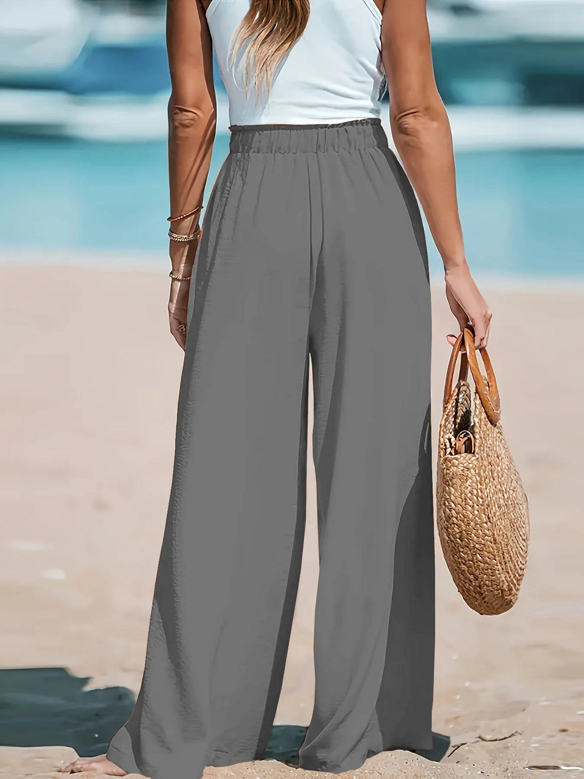 Close up shot of the smooth, non-see-through premium polyester fabric showing its fluid movement on CLOTHRA matching pants. Back side view in a color Grey