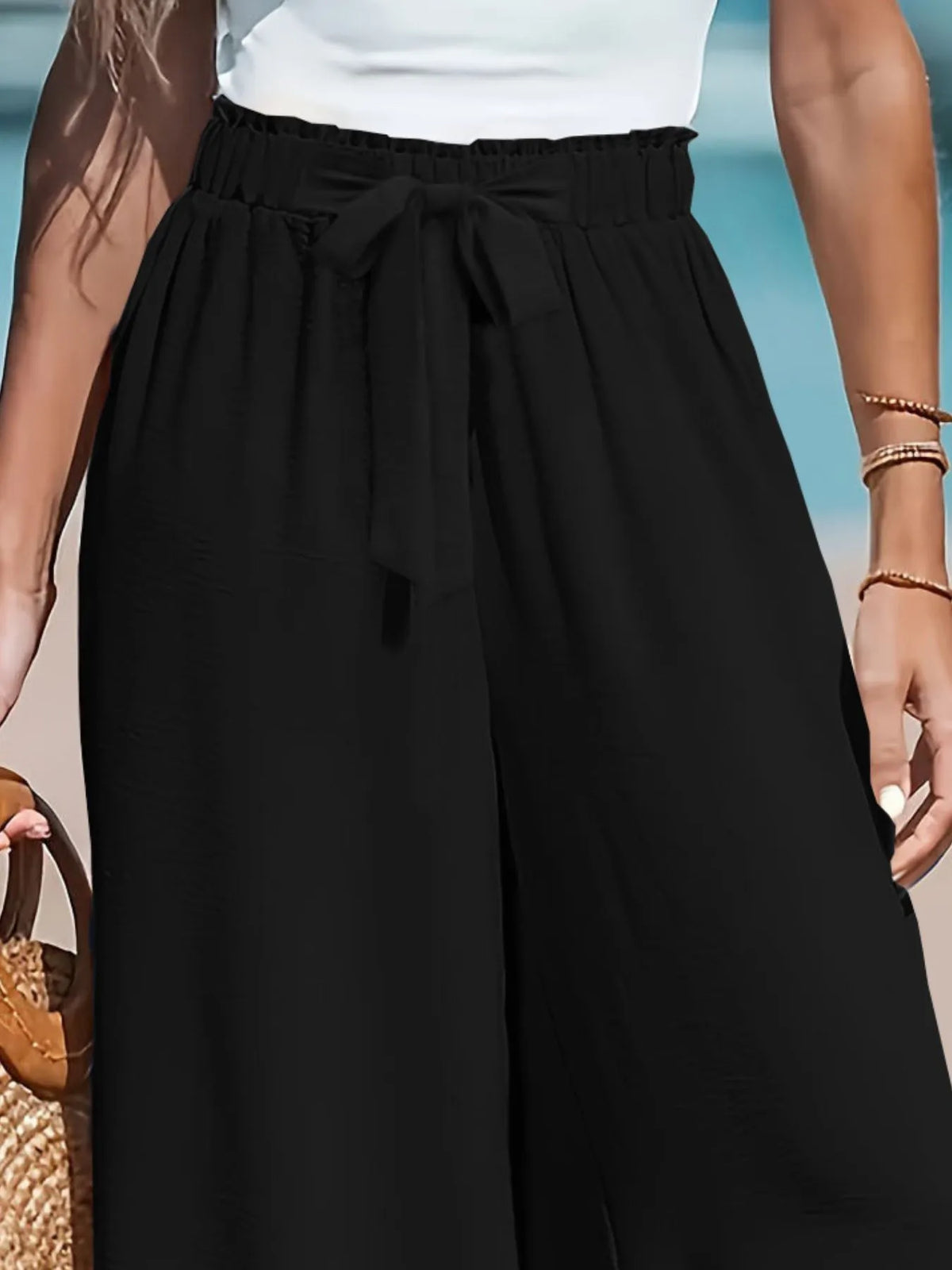 Close up of the adjustable front tied drawstring cords and secure wide flat waistband on CLOTHRA plus size trousers. in a color Black