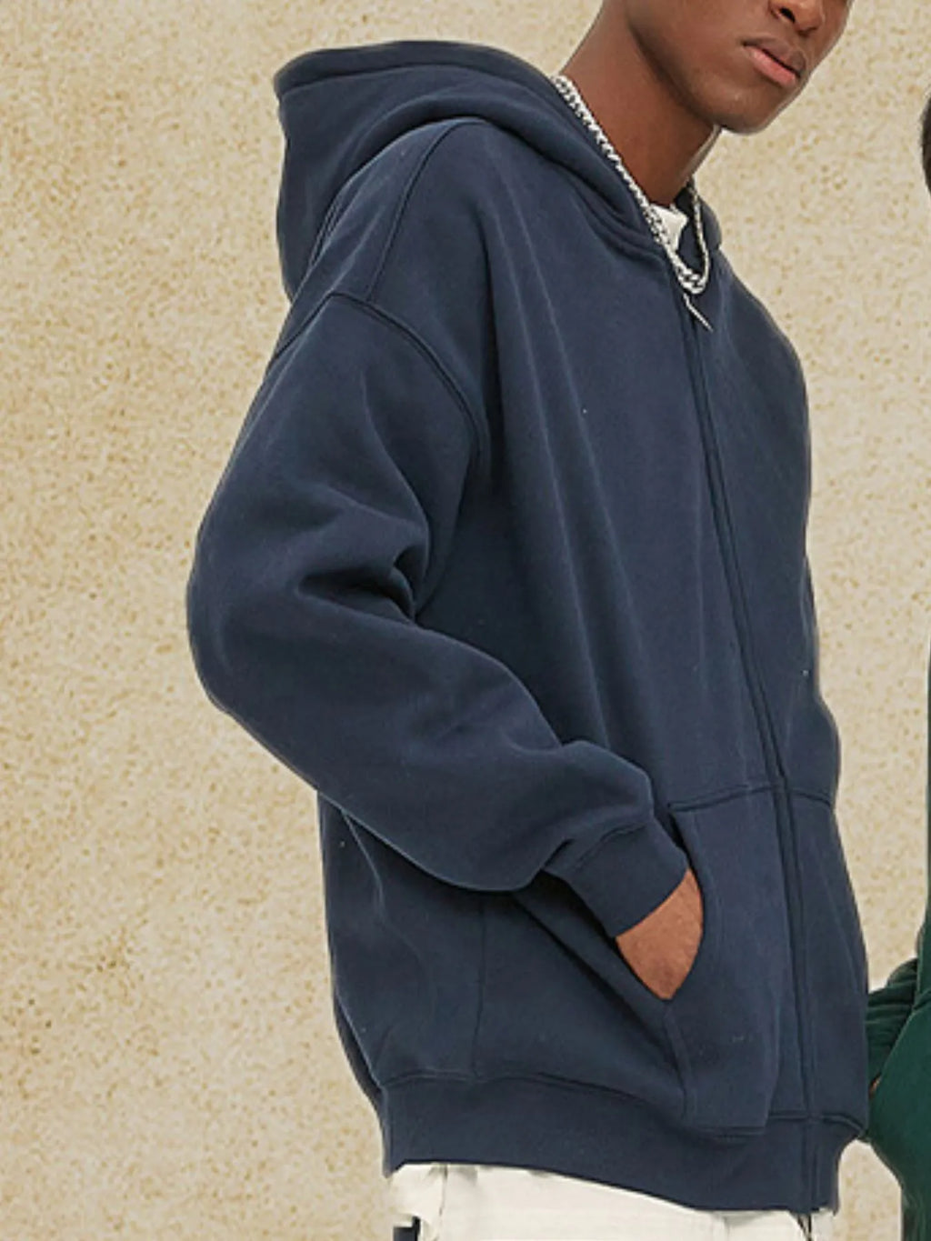 Close up of the smooth metal zipper track and reinforced kangaroo pockets on CLOTHRA unisex relaxed fleece hoodie.