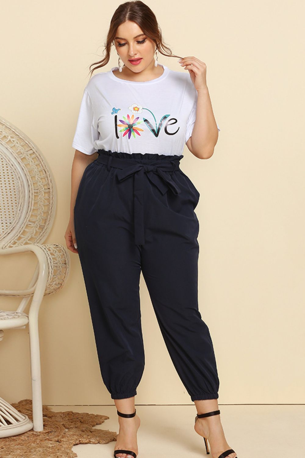 CLOTHRA women's plus size matching two piece streetwear tracksuit featuring a graphic tee and belted paperbag joggers with frill waist.
