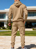 CLOTHRA men's plus size matching half zip hoodie and multi pocket cargo pants two piece utility tracksuit set in a clean urban look. Back side view in Camel color
