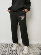 Close up shot of the secure side pockets, flexible elastic waistband, and cuffed ankles on CLOTHRA matching track pants.