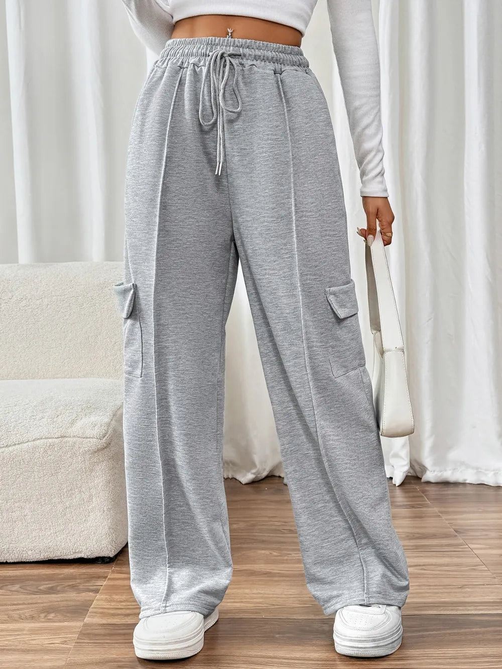 Close up of the adjustable front drawstring tie and premium polycotton fabric weave on CLOTHRA wide leg trousers.