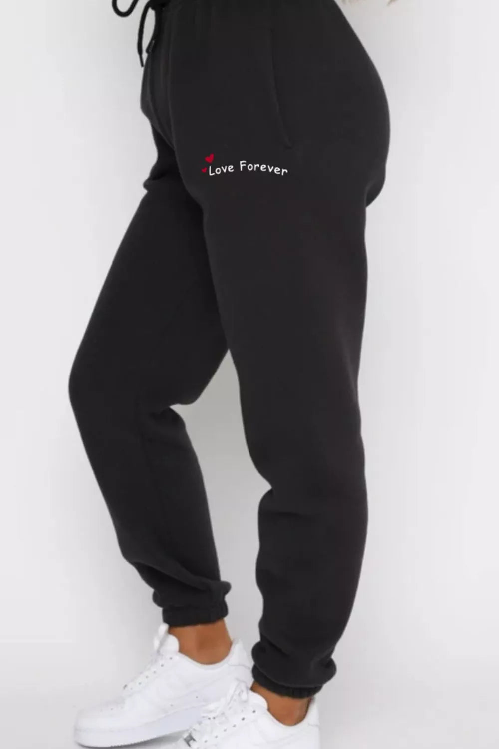 CLOTHRA matching round neck sweatshirt and cuffed joggers two piece lounge tracksuit set in a clean minimalist street look. Side view Black